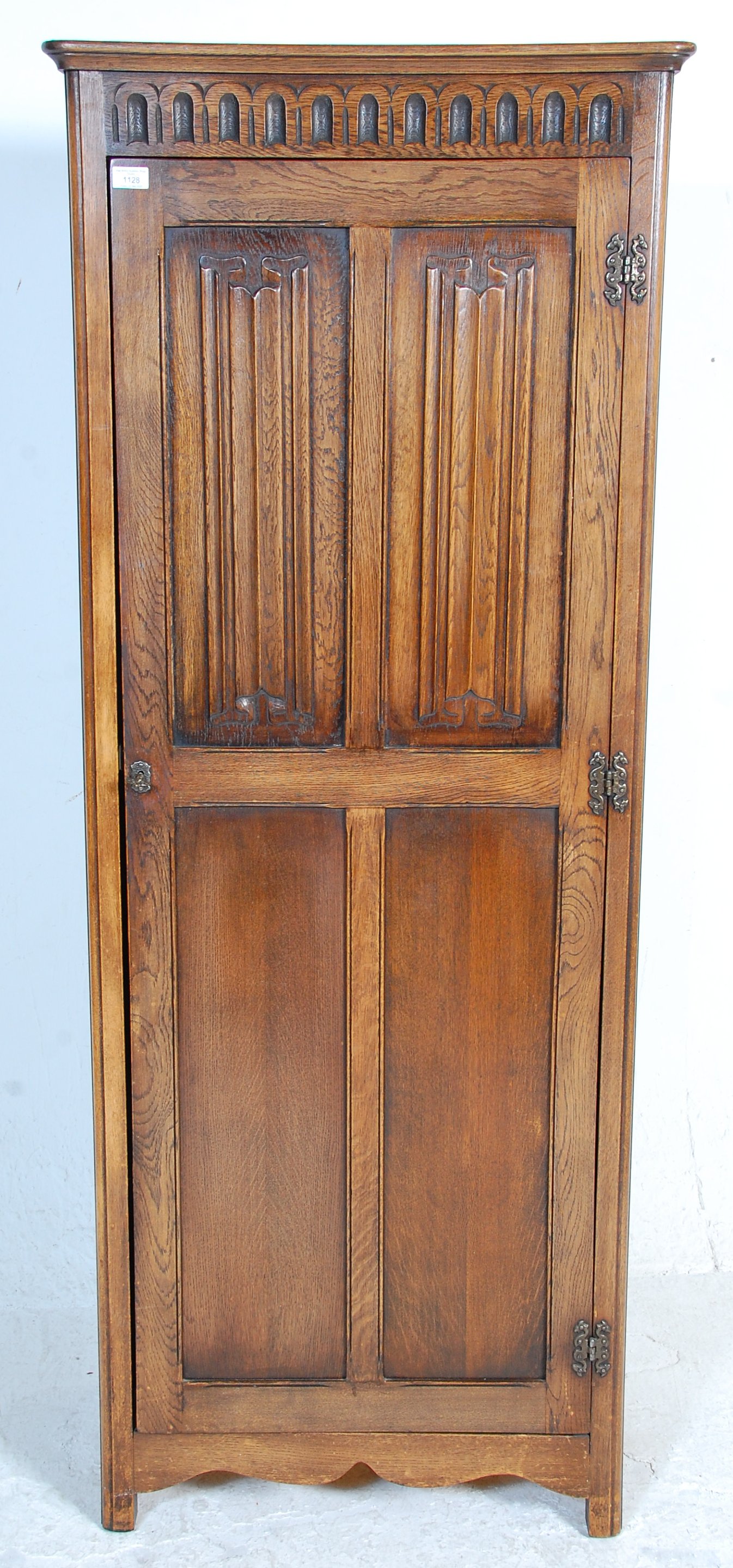 A 1930's oak Art Deco wardrobe having a singe four panelled door with carved graphic decoration to - Image 2 of 5