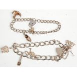 Two silver charm bracelets having silver heart padlock clasps. Adorned with charms to include a
