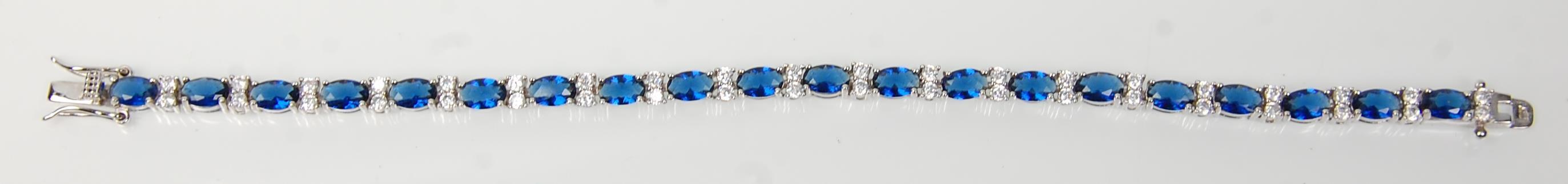 A stamped 925 silver tennis bracelet being set with oval cut blue stones with round cut white