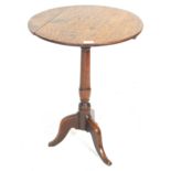 A 19th Century oak pedestal wine table having a round top with turned knopped column raised on a