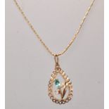 A stamped 9ct gold pendant necklace having a teardrop pendant set with a green and white stone in