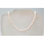 A freshwater pearl necklace of white pearls, having a gold ball clasp. Measures 17 inches. Clasp