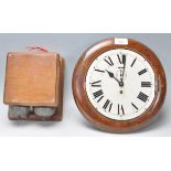 An early 20th Century station wall clock having a round white enamelled face with roman numeral to