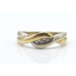 A 9ct gold and diamond bi-colour crossover ring.  The ring with white and yellow cross over design