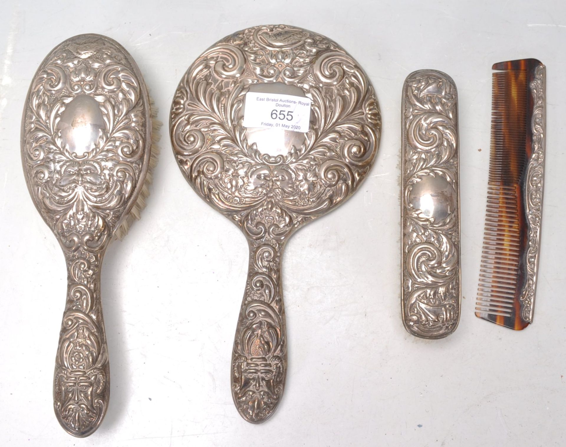 An mid 20th Century silver backed dressing table set having scrolled repousse decoration