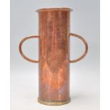 A vintage 20th Century copper twin handled vase of cylindrical form raised on a circular brass