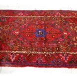 A lovely vintage 20th Century Persian / Islamic floor rug having red ground with pink, green and