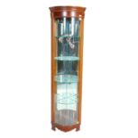 A 20th Century vintage shop display corner cabinet having a glazed bow front with glass shelves