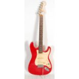 A Squier six string strat by Fender series electric guitar having a red body with white