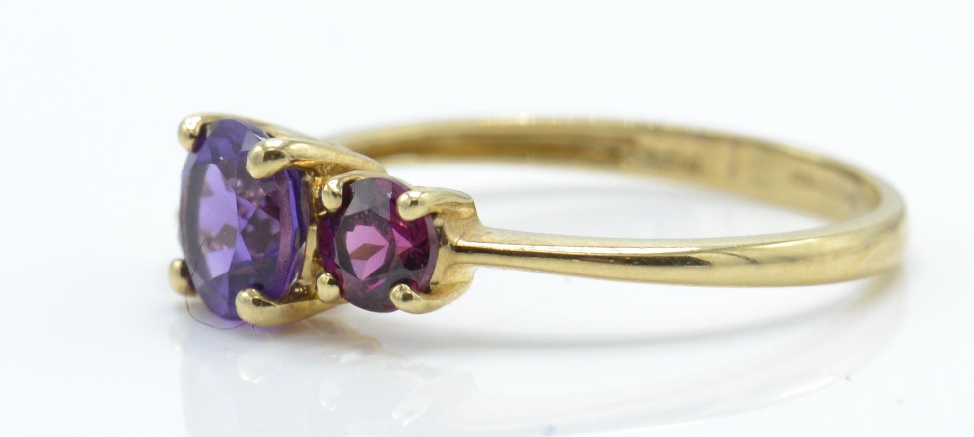 A 9ct gold Birmingham hallmarked 3 stone amethyst ring. The 3 round mixed cut amethysts in 4 prong - Image 2 of 4