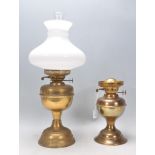 Two vintage 20th Century brass oil lamps with one having a white glass shade and funnel. Measures 51