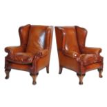 An excellent pair of 20th Century brown leather upholstered wingback chesterfield armchairs having
