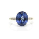 A 9ct white gold Birmingham hallmarked blue stone and diamond ring. THe central oval mixed cut