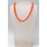 A 20th Century coral beaded necklace having spherical beads strung on a spring ring clasp.