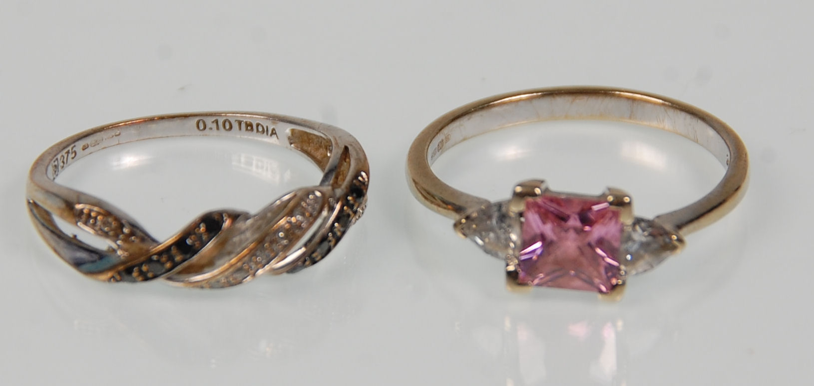 Two 9ct white gold ladies rings. One set with a square cut pink stone flanked by CZs. Hallmarked for