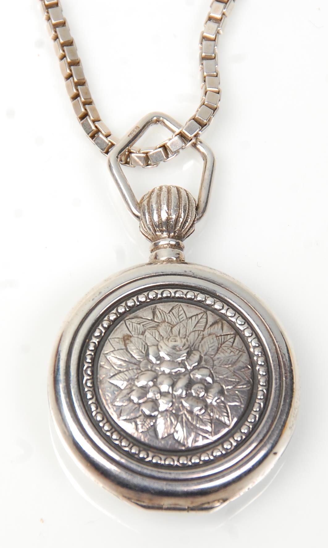 A stamped 925 silver locket of round form having repousse floral decoration on a stamped 925 - Image 4 of 5