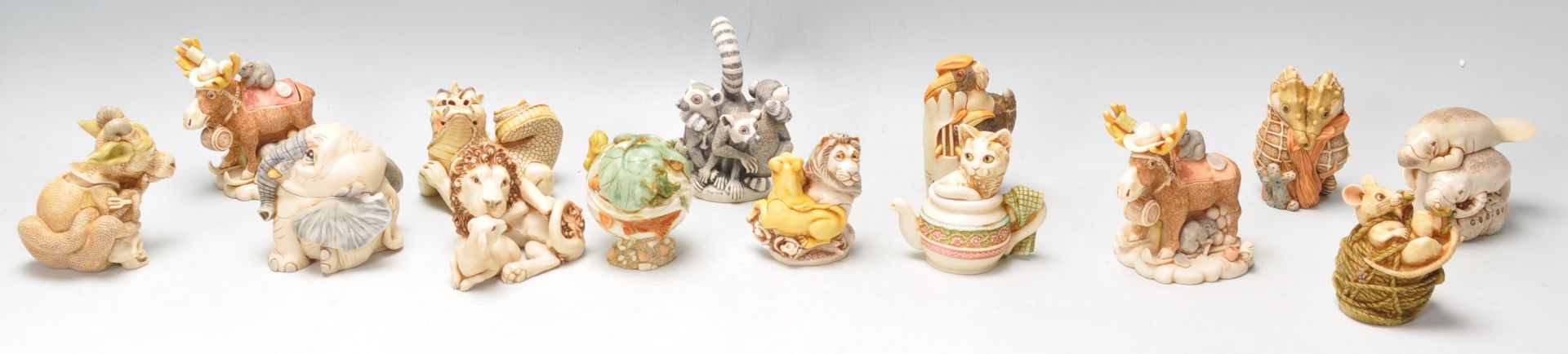 A group of fourteen Harmony Kingdom resin novelty figurines to include an elephant box, a lion and a