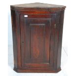 A 19th Century George III country  antique elm  hanging corner cabinet having a panelled door with