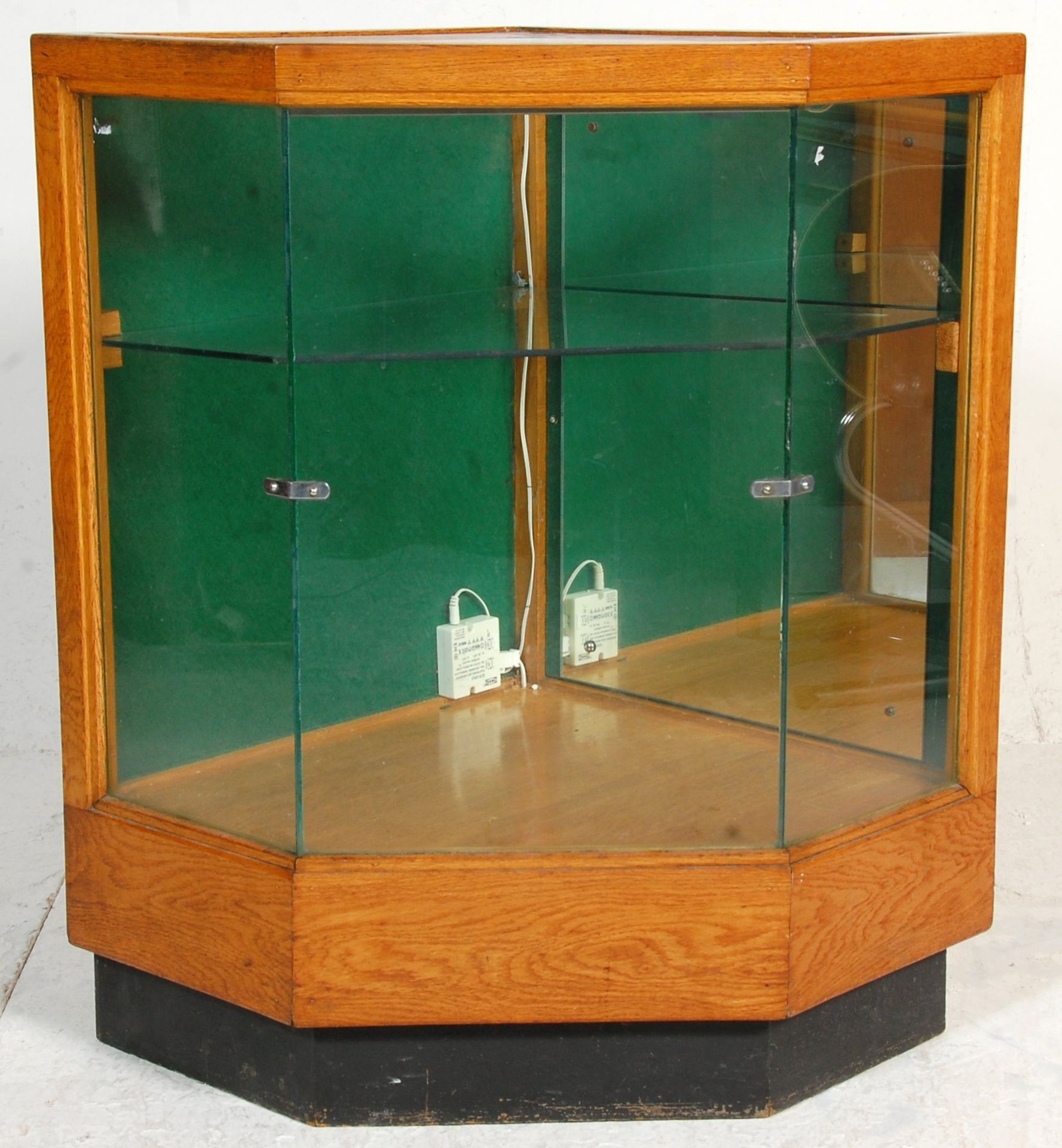 A retro mid century shop haberdashery corner counter cabinet. The oak body with plinth base having