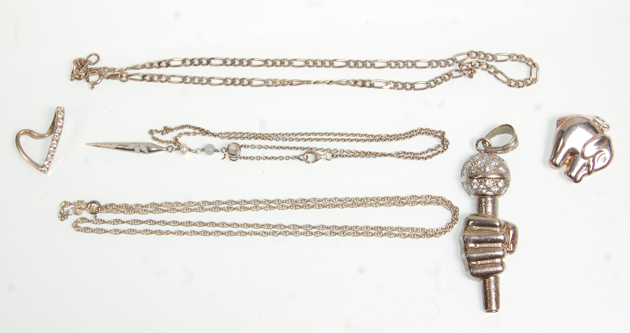 A group of silver chains and pendants to include a large pendant in the form of a hand holding a