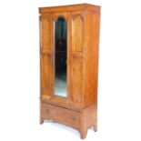 An early 20th Century 1930's oak wardrobe having three domed panelled doors, the central door having