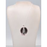A stamped sterling silver pendant necklace having a fine link chain with a pendant in the form of