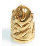 A gold plated thimble in the form of a frog having
