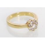 A stamped 18ct gold diamond cluster ring having a