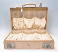An early 20th Century white leather travel vanity