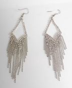 A pair of ladies silver dress earrings being set w
