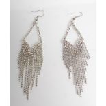 A pair of ladies silver dress earrings being set w