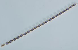 A stamped 750 18ct gold tennis bracelet set with t