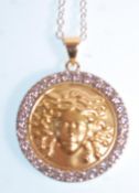An 18ct gold pendant of round form having a round