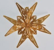 An unmarked 18ct gold filigree brooch in the form