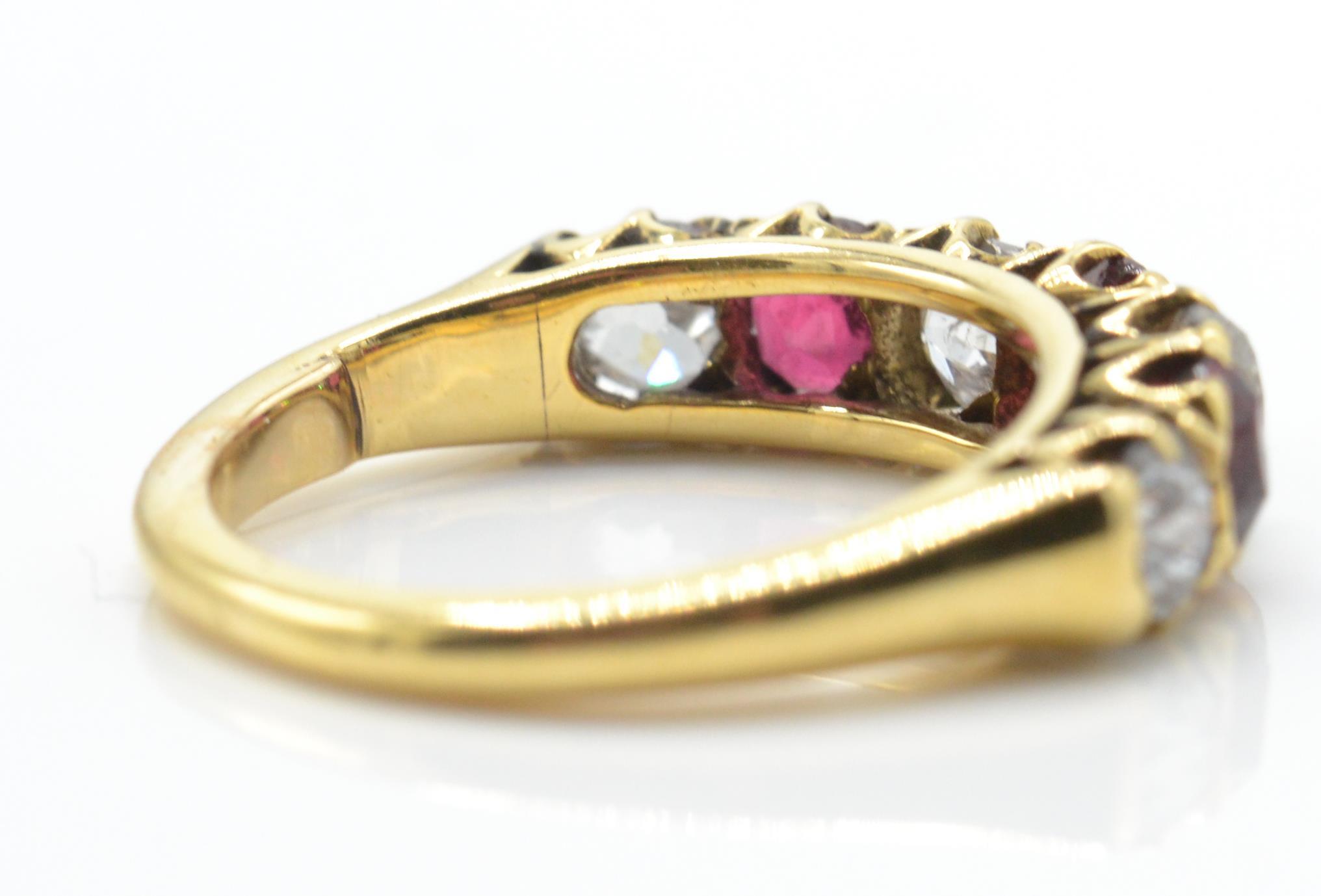 An 18ct gold garnet and diamond 7 stone band ring. The ring set with alternating garnets - Image 4 of 4