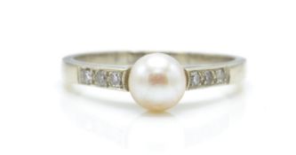 A 9ct white gold, pearl and diamond ring. The ring set with a central pearl