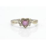 A hallmarked 9ct white gold pink stone and diamond ring. The ring having a central heart cut pink