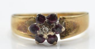 An 18ct gold London hallmarked ruby and diamond ring cluster ring.