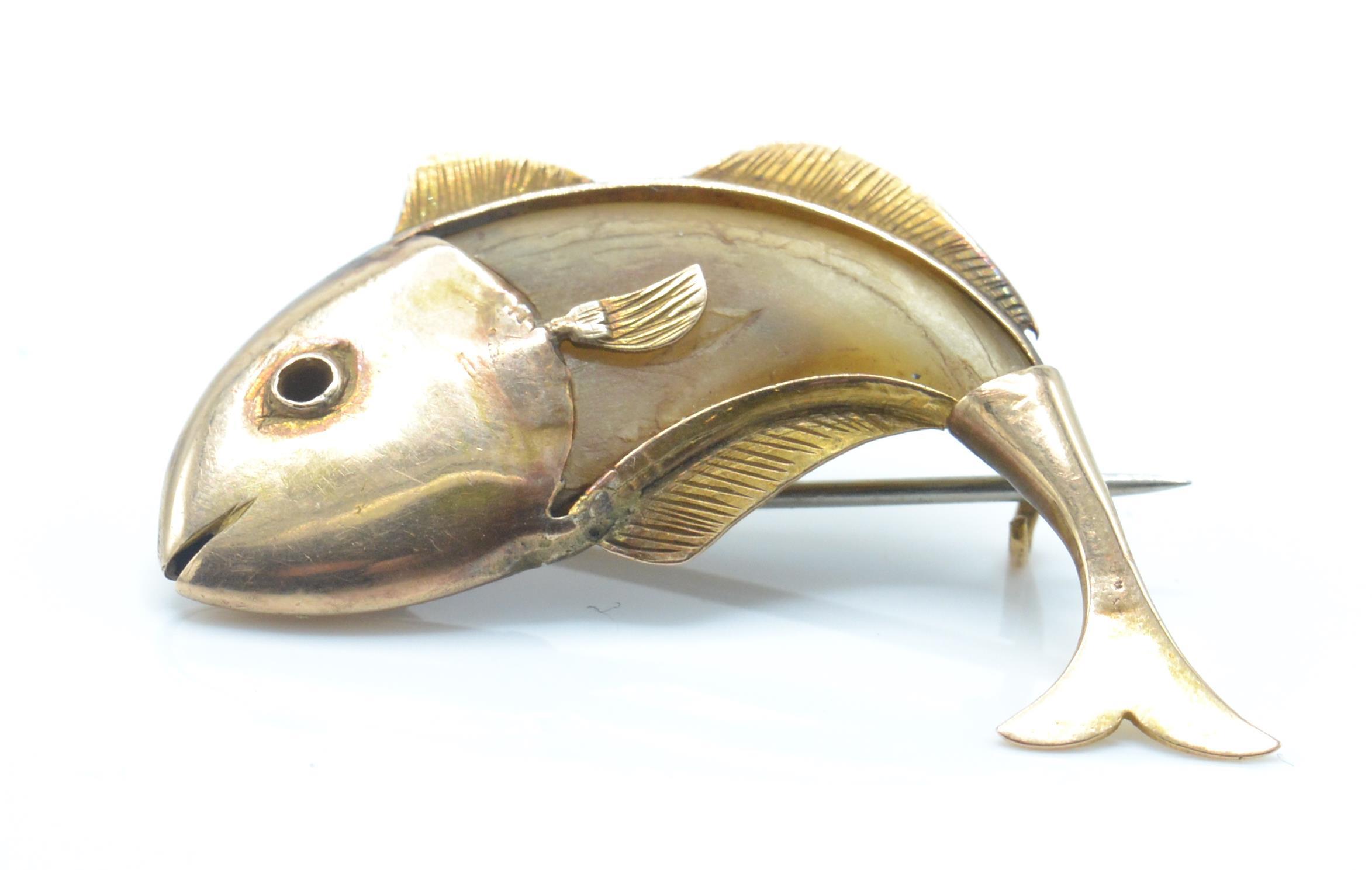A vintage gold and horn figural brooch pin. The brooch on the form of a fish having a horn body
