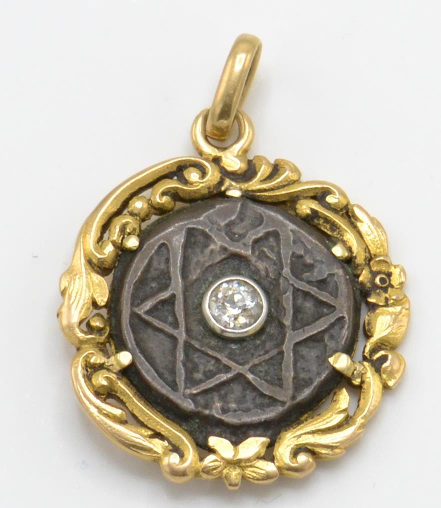 A 19th century gold and diamond pendant. The pendant having a gold scrolled foliate mount