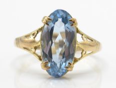 A hallmarked 9ct gold ring. The ring set with an oval pale blue mixed cut stone
