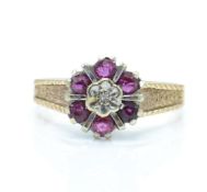 A 1970's hallmarked 9ct gold ruby and diamond cluster ring. The ring having a central illusion set