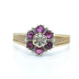 A 1970's hallmarked 9ct gold ruby and diamond cluster ring. The ring having a central illusion set