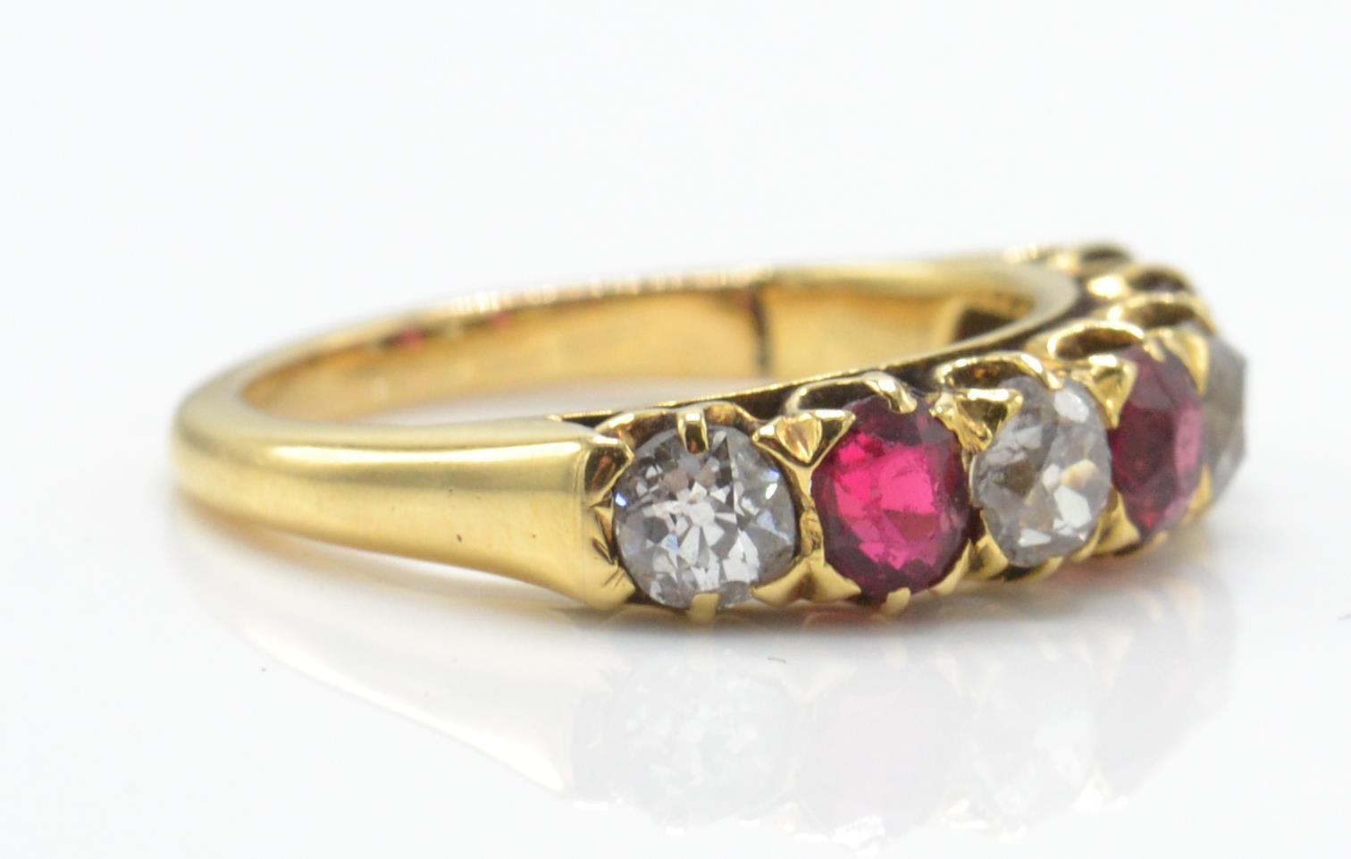 An 18ct gold garnet and diamond 7 stone band ring. The ring set with alternating garnets - Image 3 of 4