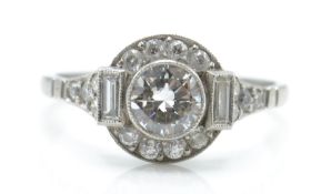 An Art Deco platinum and diamond ring. The ring set with a central round brilliant cut diamond