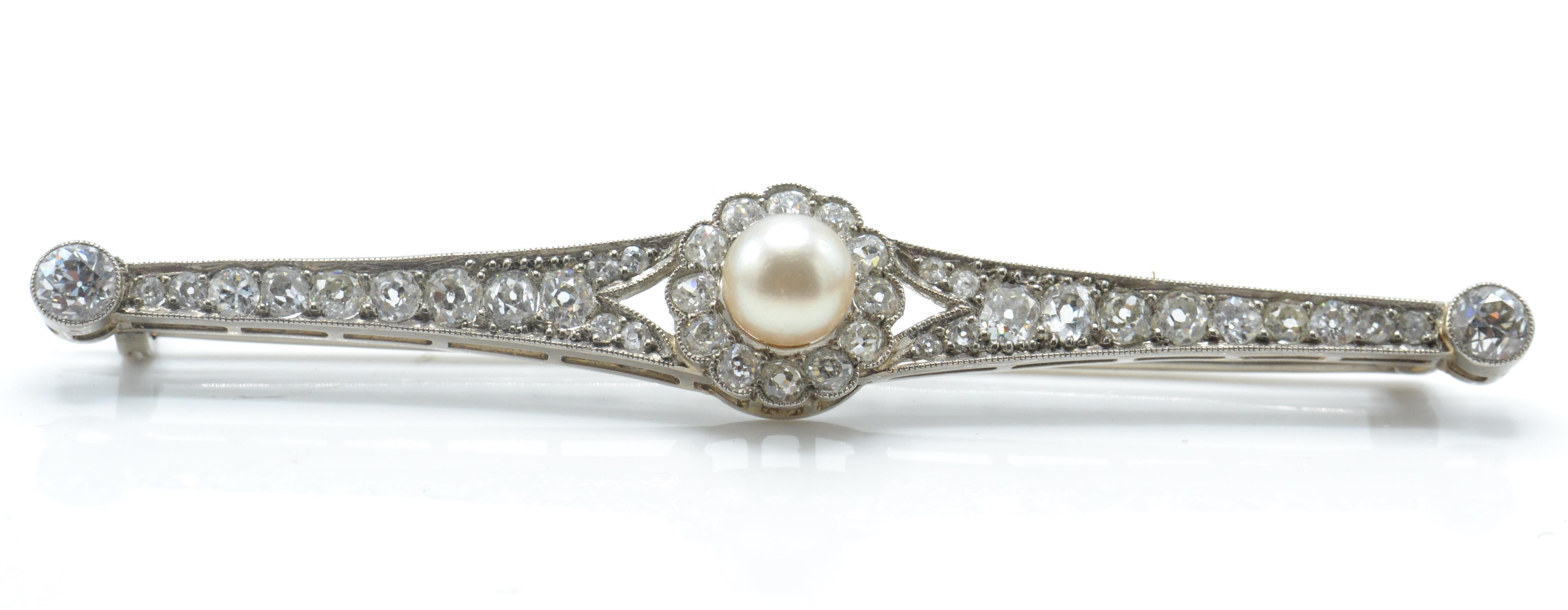 A 14ct white gold pearl and diamond bar brooch pin. The brooch set with a central pearl