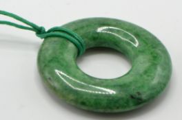 A large Chinese green hardstone roundel Bi pendant. The pendant formed of a pierced roundel of
