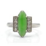 An Art Deco platinum, diamond and nephrite ring. The ring set with a green cabochon possible