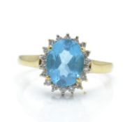 A hallmarked 9ct gold topaz and diamond cluster ring. The ring set with a central large oval mixed