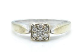 A hallmarked 9ct white gold and diamond ring. The ring having a cluster of diamonds within a